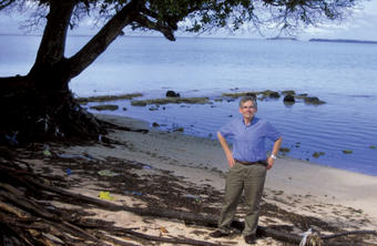 Signs of the damage caused by rising waters due to climate change are everywhere in the Marshall Islands. Michael Gerrard ’72 stands on a beach where much of the sand has been washed away, exposing the trees’ roots and threatening their survival. PHOTO: Derrain Cook